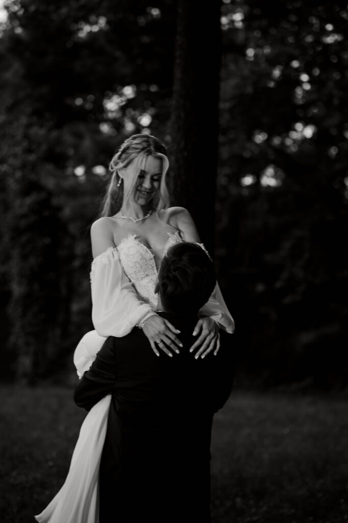 Zdjęcie przedstawia szczęśliwą parę młodą w leśnym otoczeniu, symbolizując miłość i wyjątkowy dzień ślubu.