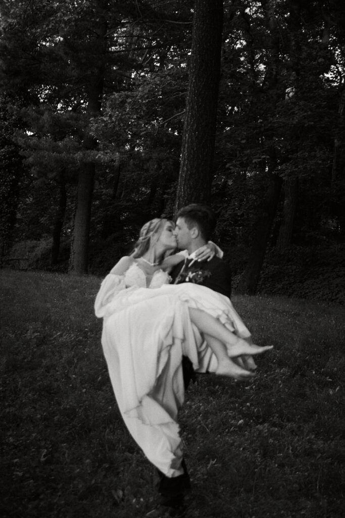 Alt: Para młoda w romantycznej sesji plenerowej w lesie, czarno-białe zdjęcie, miłość i natura.