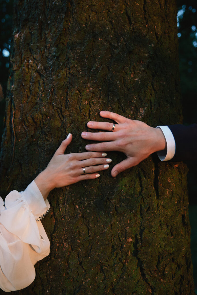 Zdjęcie ukazuje romantyczny moment z rękami na drzewie, podkreślając intymność i więź.
