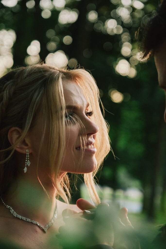 Przedstawienie młodej pary podczas sesji w plenerze, z romantycznym ujęciem wśród zieleni.