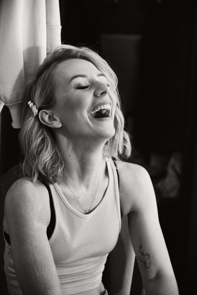 Uśmiechnięta kobieta podczas sesji fotograficznej w studiu Blizej Studio.