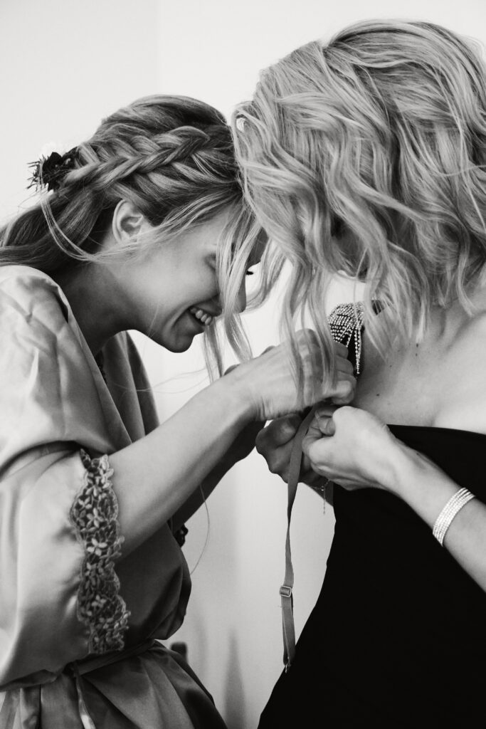 Kobiety zbliżają się do siebie, uśmiechając się podczas tworzenia biżuterii.