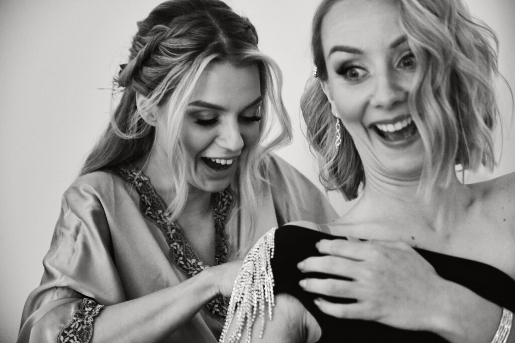 Czarno-białe zdjęcie z kobietami, które się śmieją i cieszą podczas sesji zdjęciowej w studiu Blizej Studio.