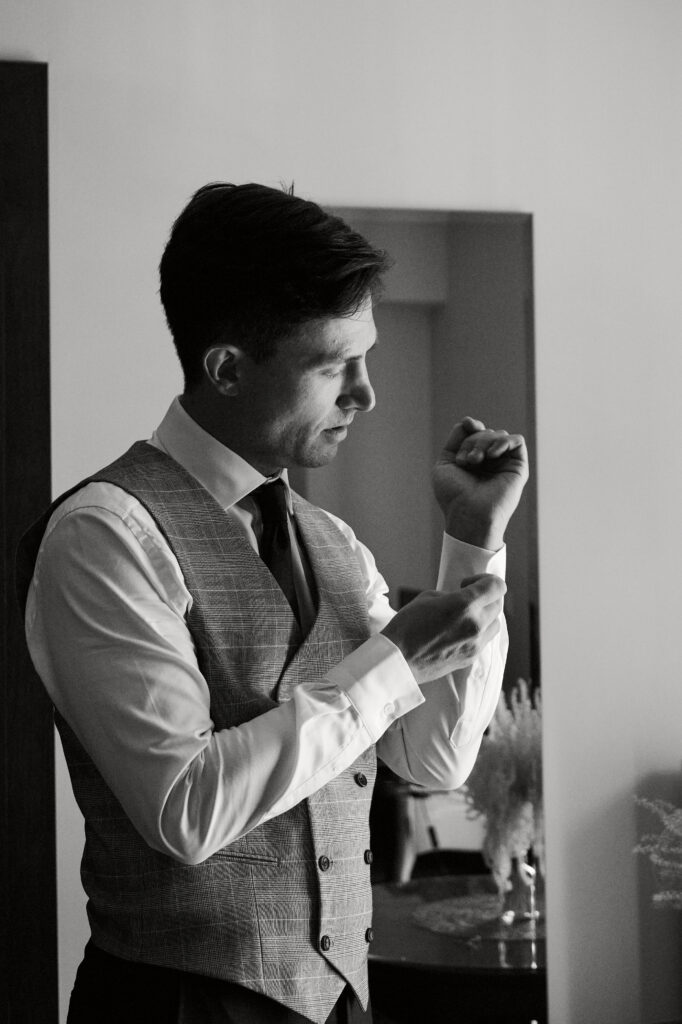 Mężczyzna w marynarce, poprawiający mankiet, elegancja, styl, moda męska.