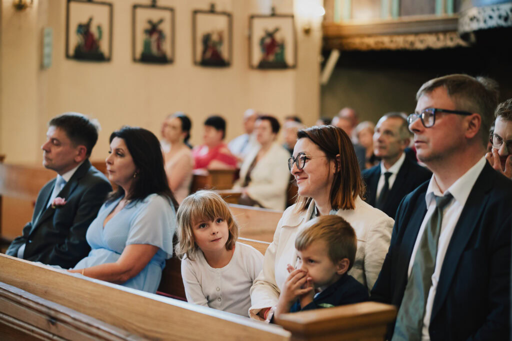 Uczestnicy wesela w kościele, emocjonalna ceremonia, rodzina i znajomi, ważny moment, stylowe wydarzenie rodzinne.