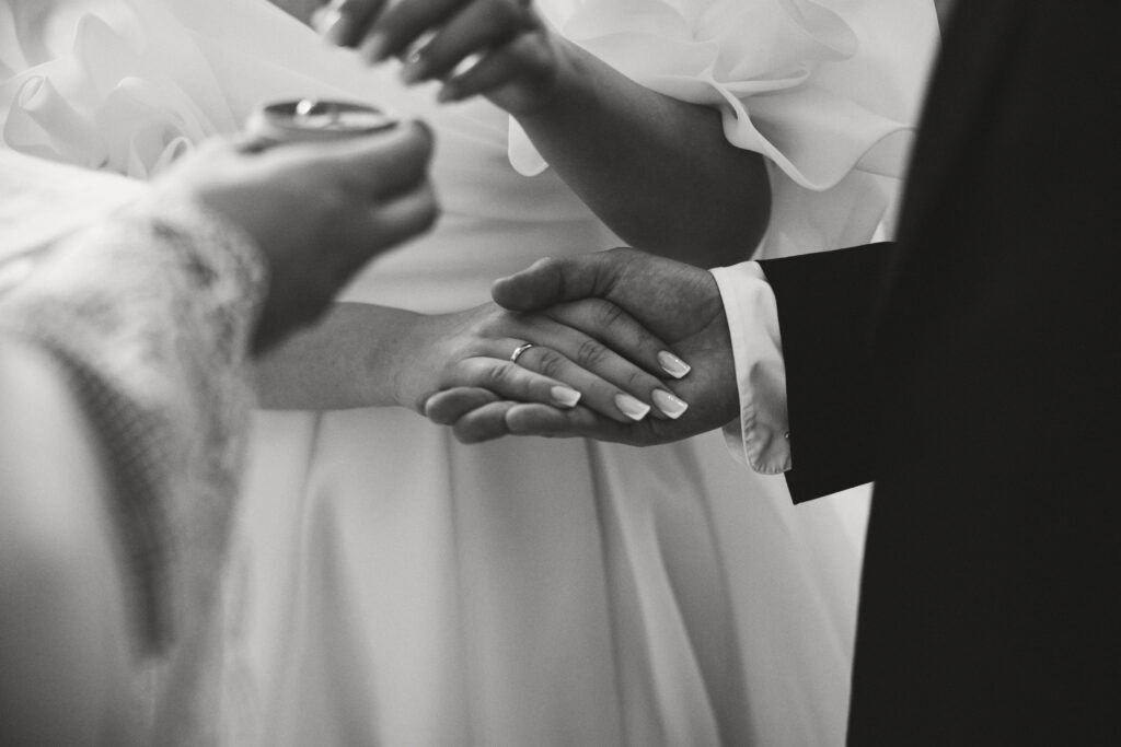 Zdjęcie zbliżenie na ręce nowożeńców podczas ceremonii ślubnej.