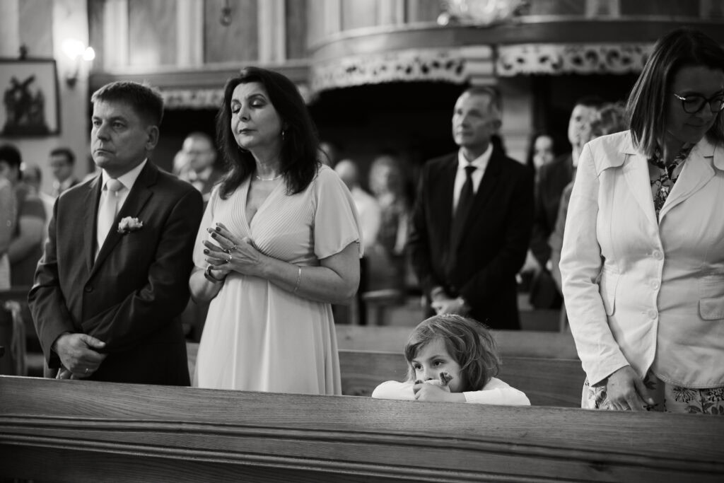 Dziecko w kościele, moment zadumy i spokoju podczas ceremonii religijnej.