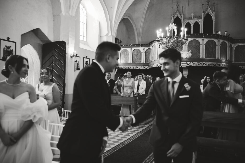 Alt text: Para młoda ślubna w kościele, ceremonię i gości podczas ślubu, elegancja i atmosfera w świątyni.