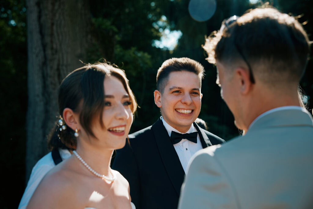 Uroczystość ślubna wśród zieleni i drzew, romantyczny moment zawarcia związku.