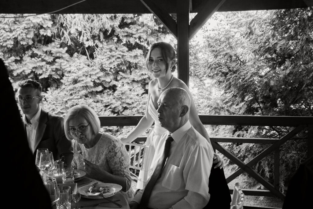 Elegancka fotografia restauracyjna, ujęcie z przyjęcia na świeżym powietrzu, czas rodzinny, wyrafinowany klimat, naturalne światło.