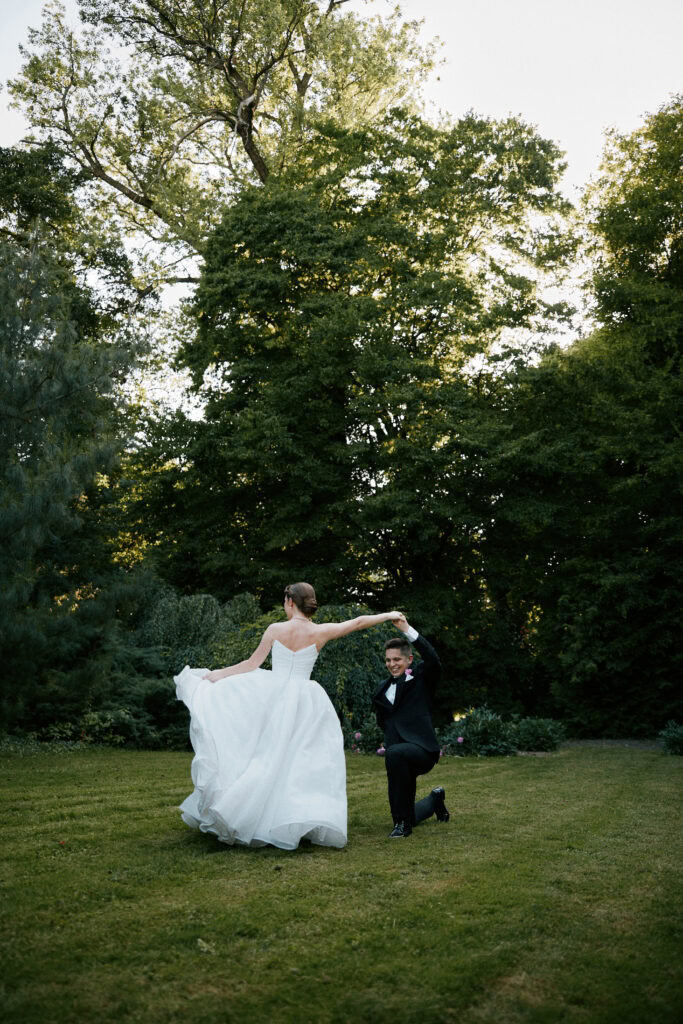 Para młoda tańczy na zielonym trawniku, w tle drzewa, romantyczna atmosfera, ślub, wesele.