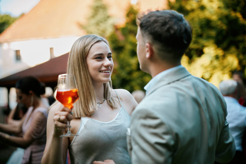 Jasna kobieta z drinkiem podczas imprezy na świeżym powietrzu, ujęcie emocji, relacji i atmosfery wydarzenia.