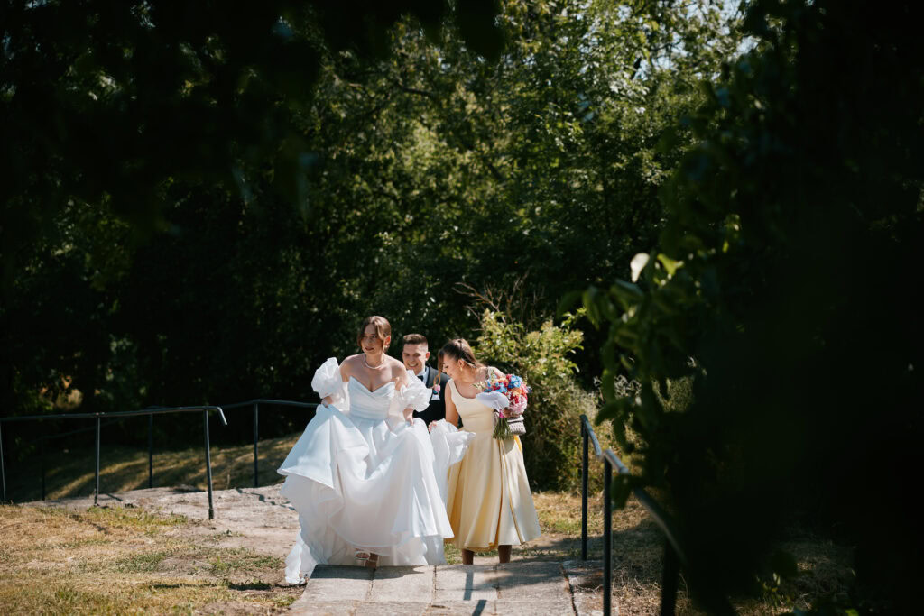 Wesele na łonie natury z piękną panną młodą i druhną, romantyczne świętowanie wśród zieleni.